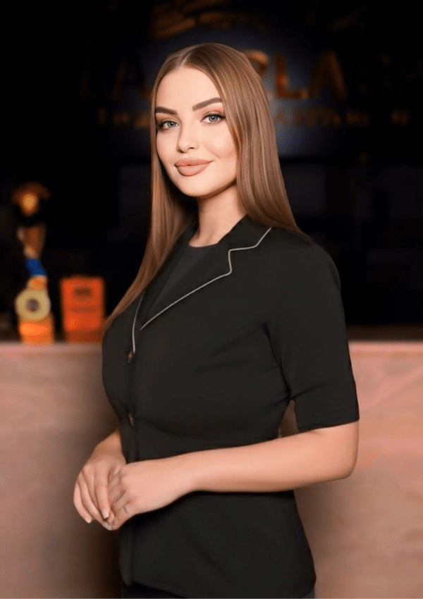 Russian therapist posing in front of award wall La Perla Spa
